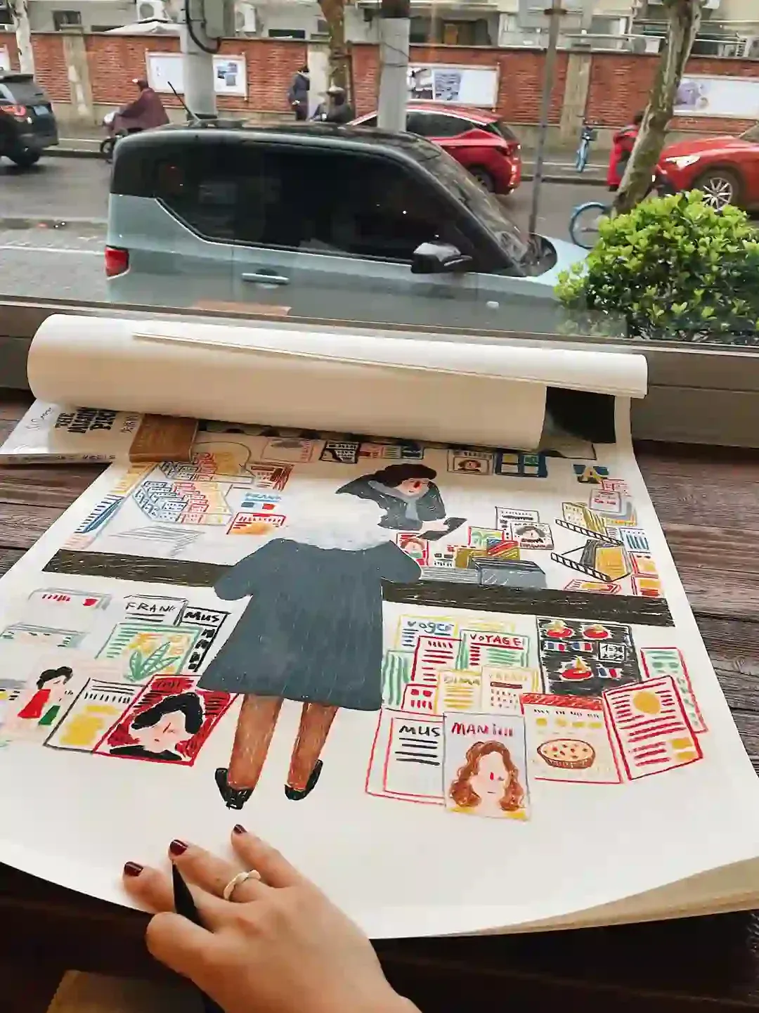 Large-format Paris bookshop illustration unrolled on a table by the window