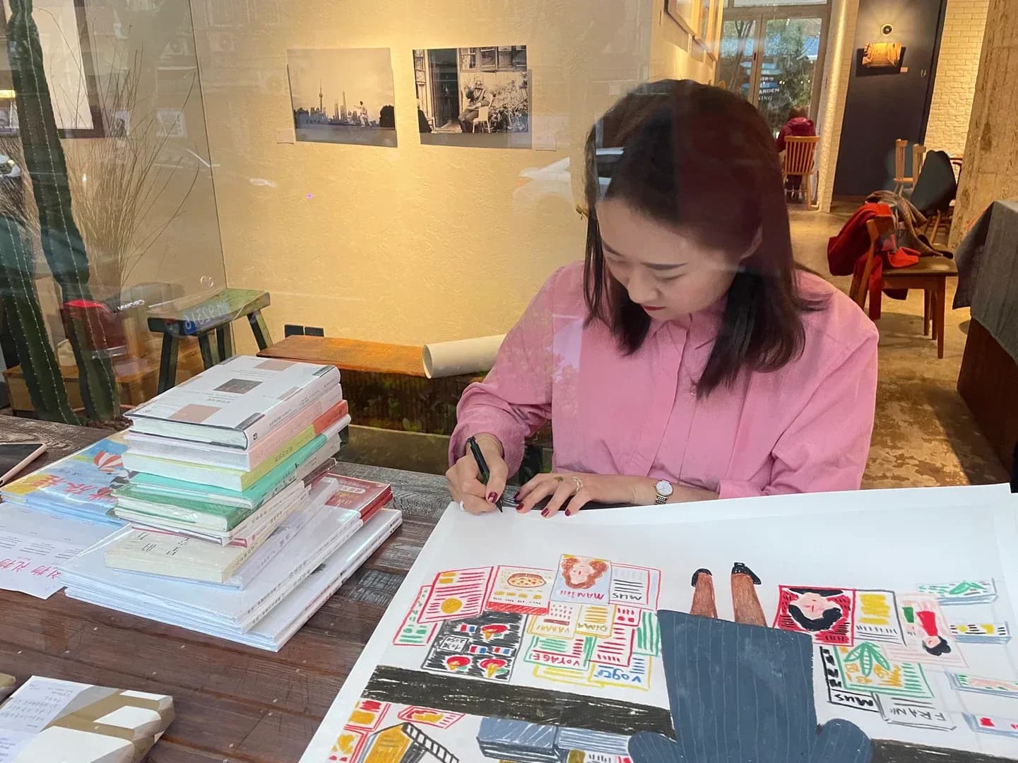 Aviva Dashuang drawing an enlarged illustration in a bookshop setting